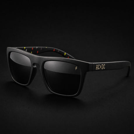 AC/DC High Voltage Sunglasses - front three-quarter view, matte black frame, smoke lens, AC/DC temple logo and lightning bolt arm interior